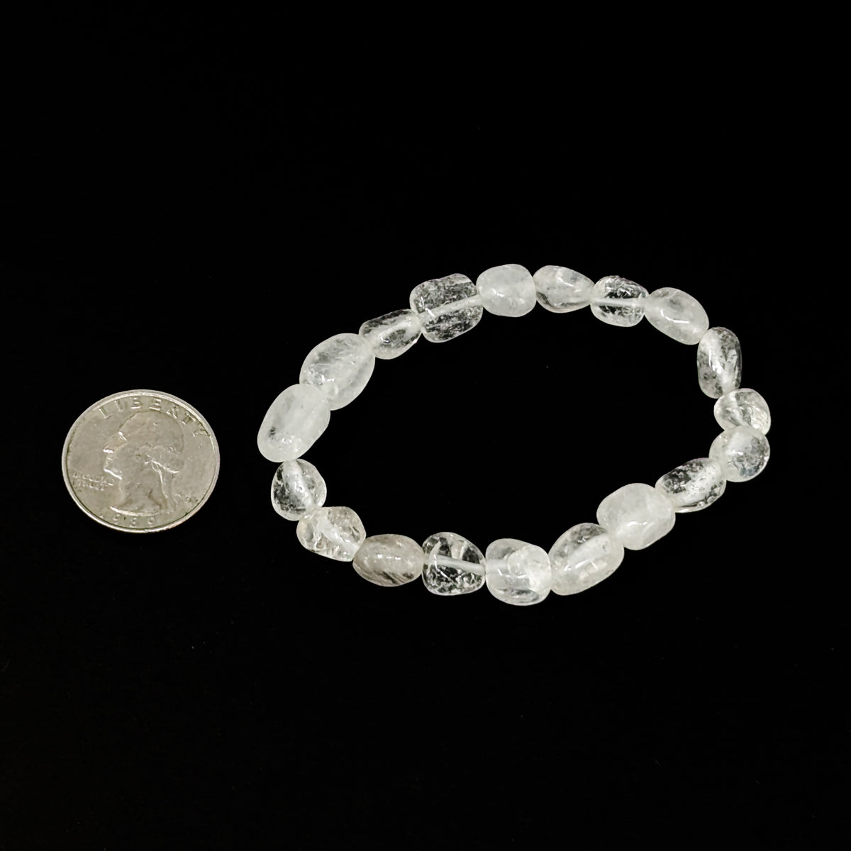 Clear quartz tumble bead bracelet – bracelet beside a coin for scale