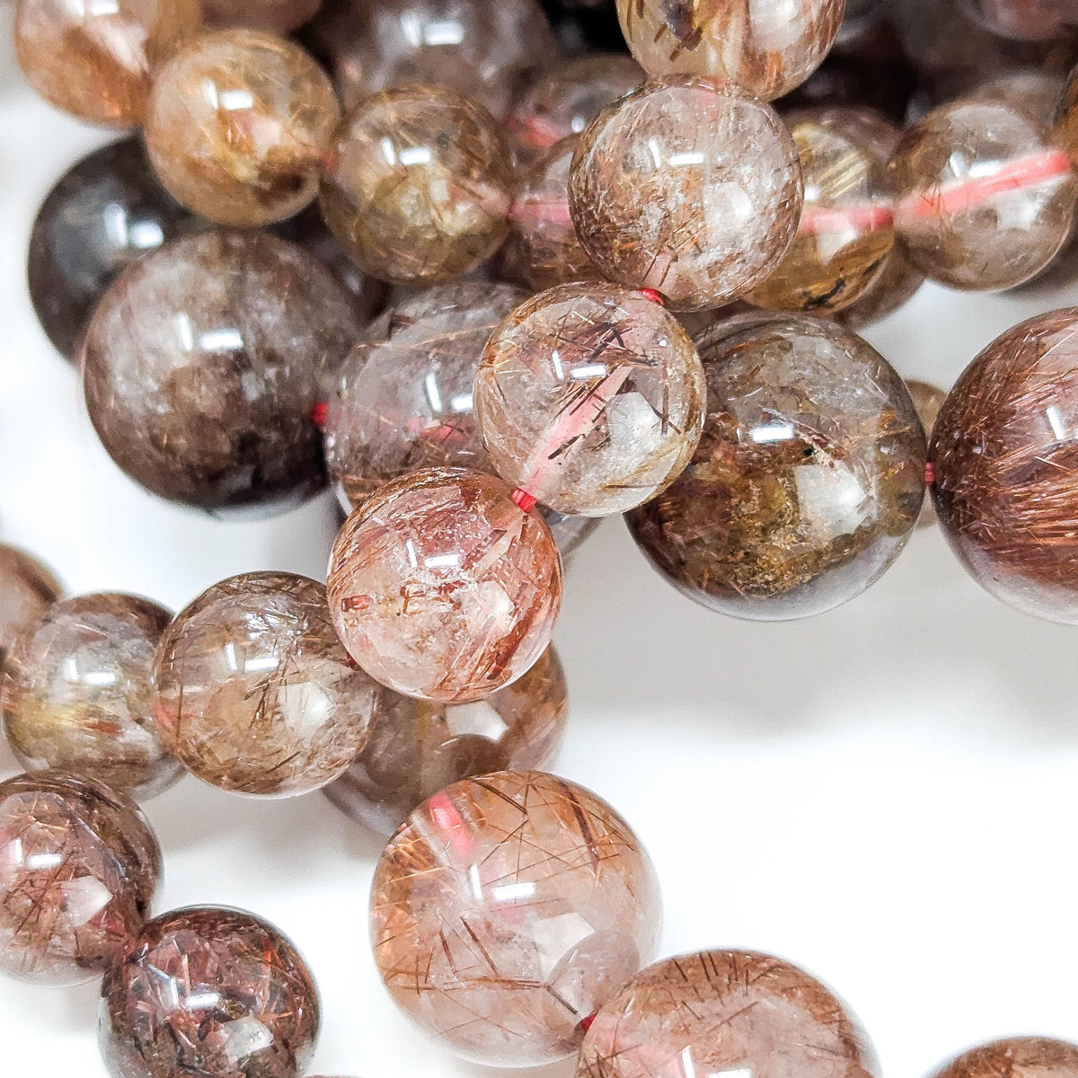 Copper rutile in quartz bead bracelet from Brazil – close-up of needle inclusions in beads