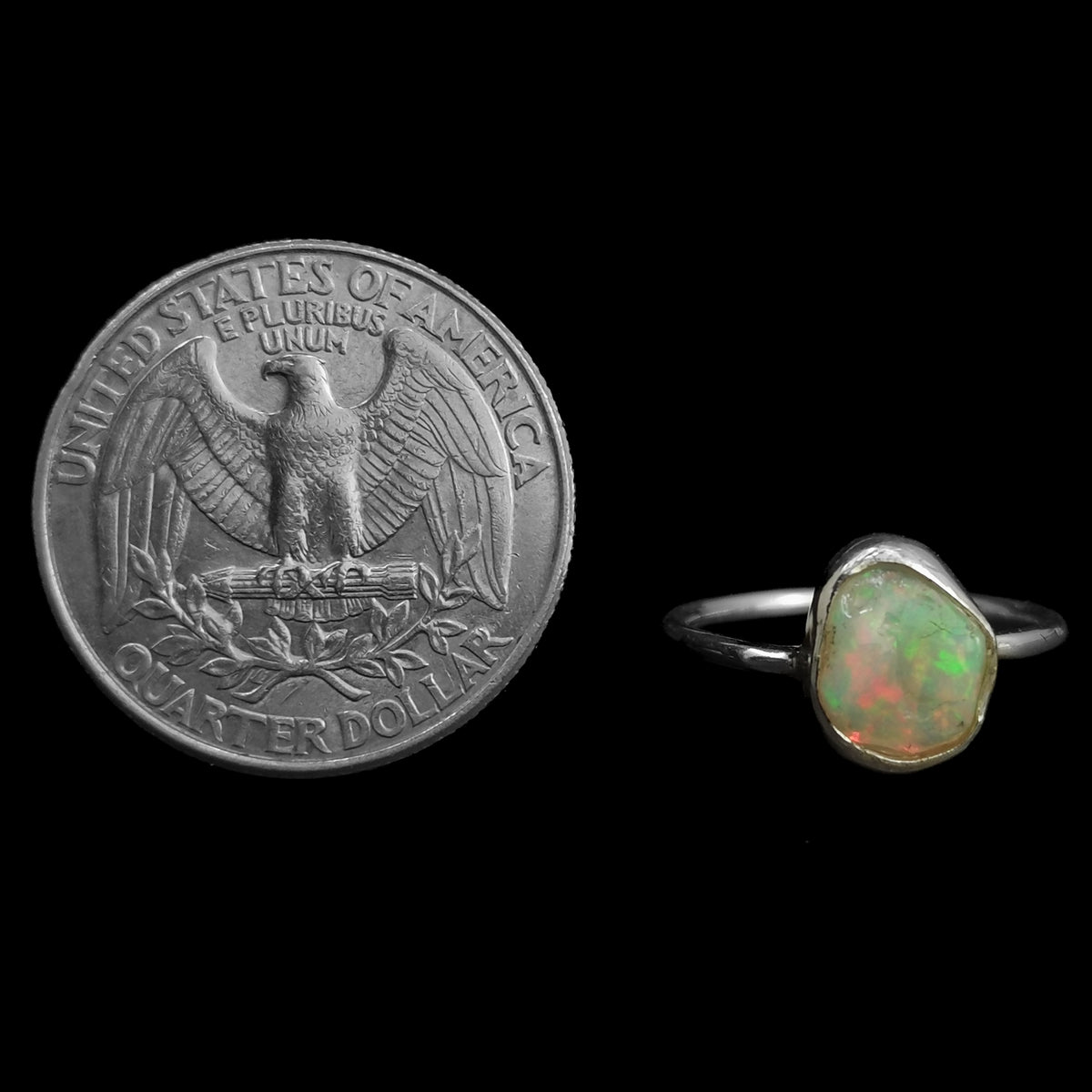Ethiopian opal freeform ring: ring beside a coin for scale