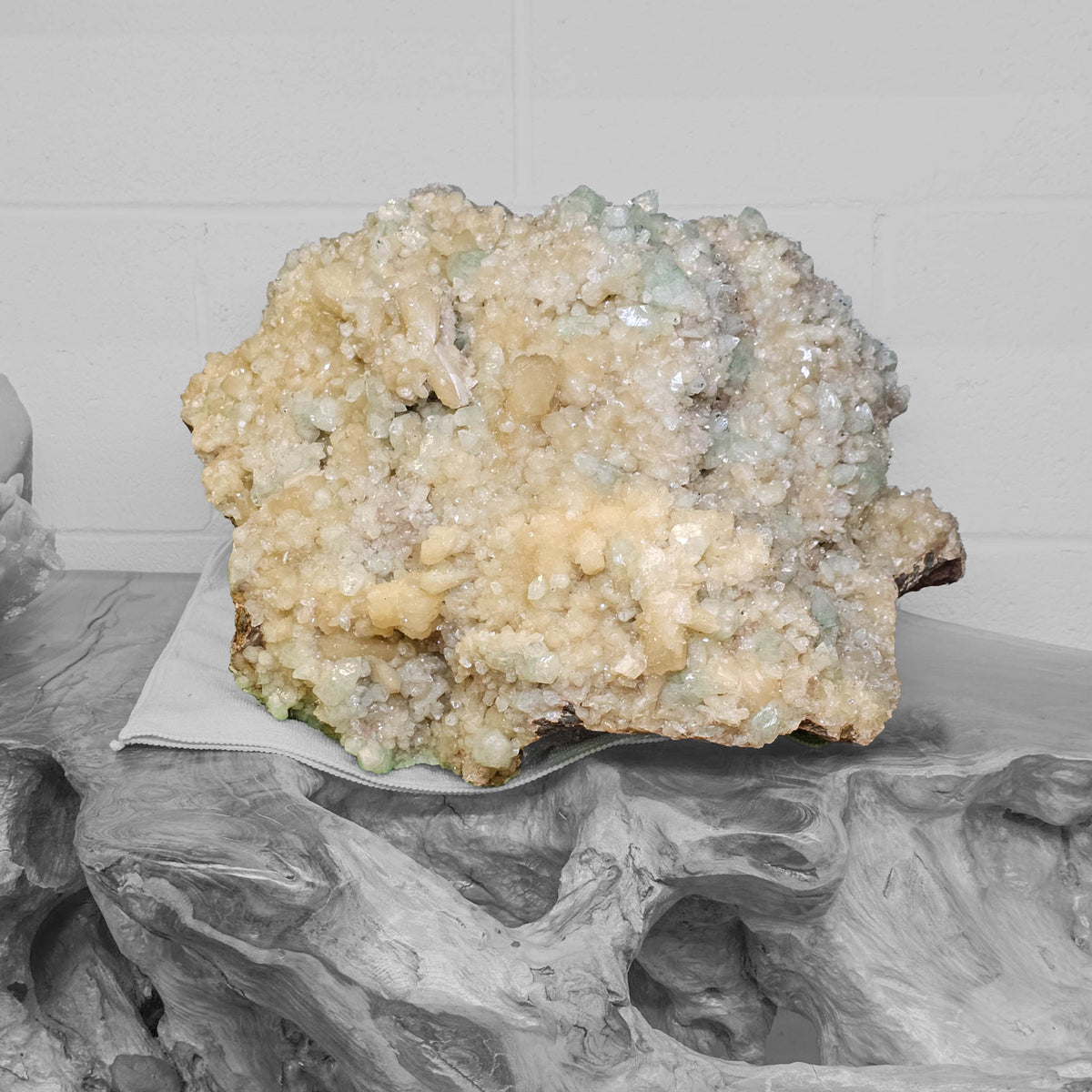 Stilbite with green apophyllite crystal cluster from Pune, India – on a carved wood stand, angled view