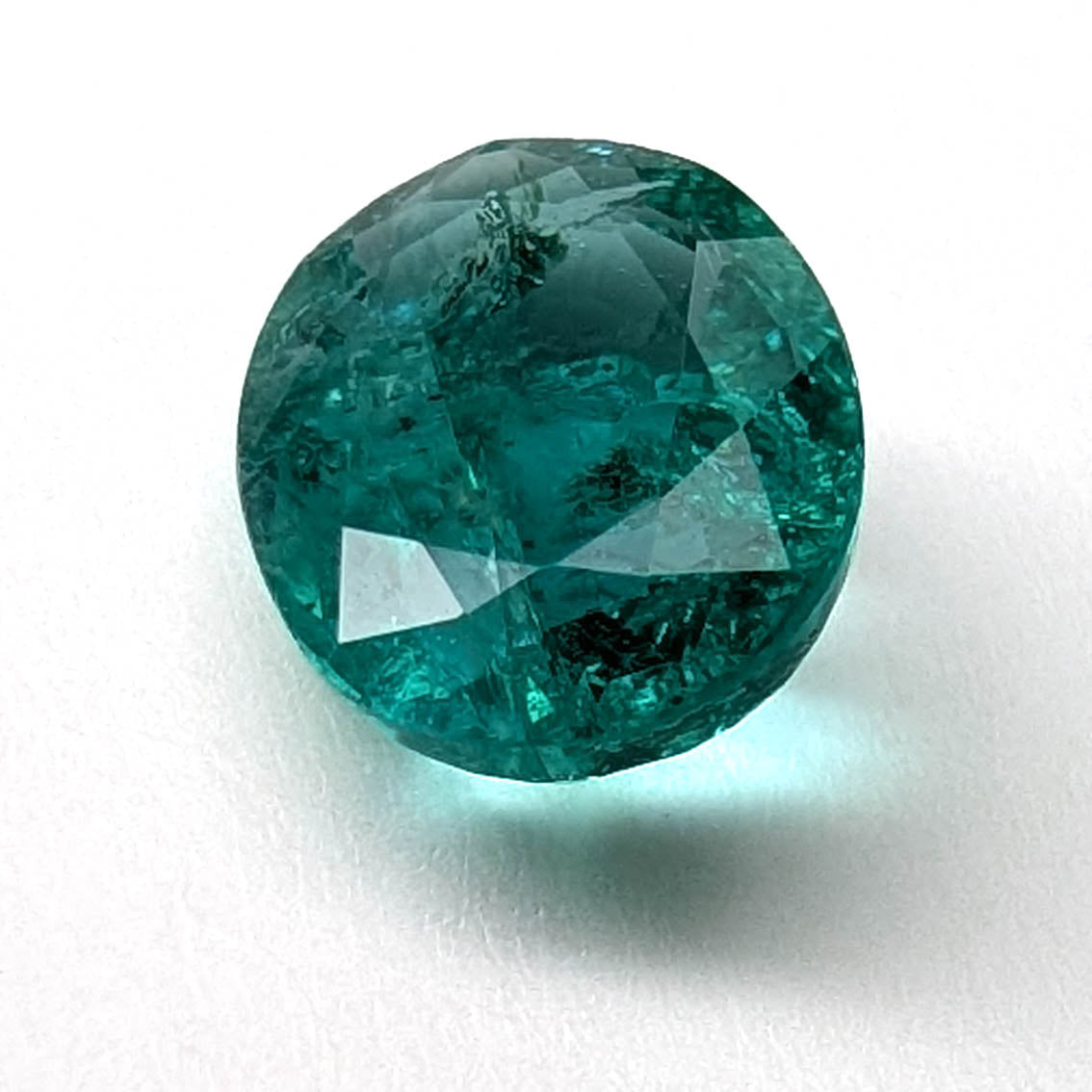 Emerald faceted oval gemstone, 1.90ct, face-up view of the table on a white background, view 1 of 13