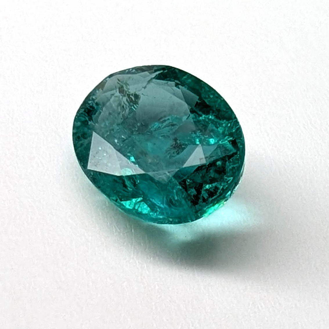 Emerald faceted oval gemstone, 1.90ct, angled view on a white background, view 5 of 13
