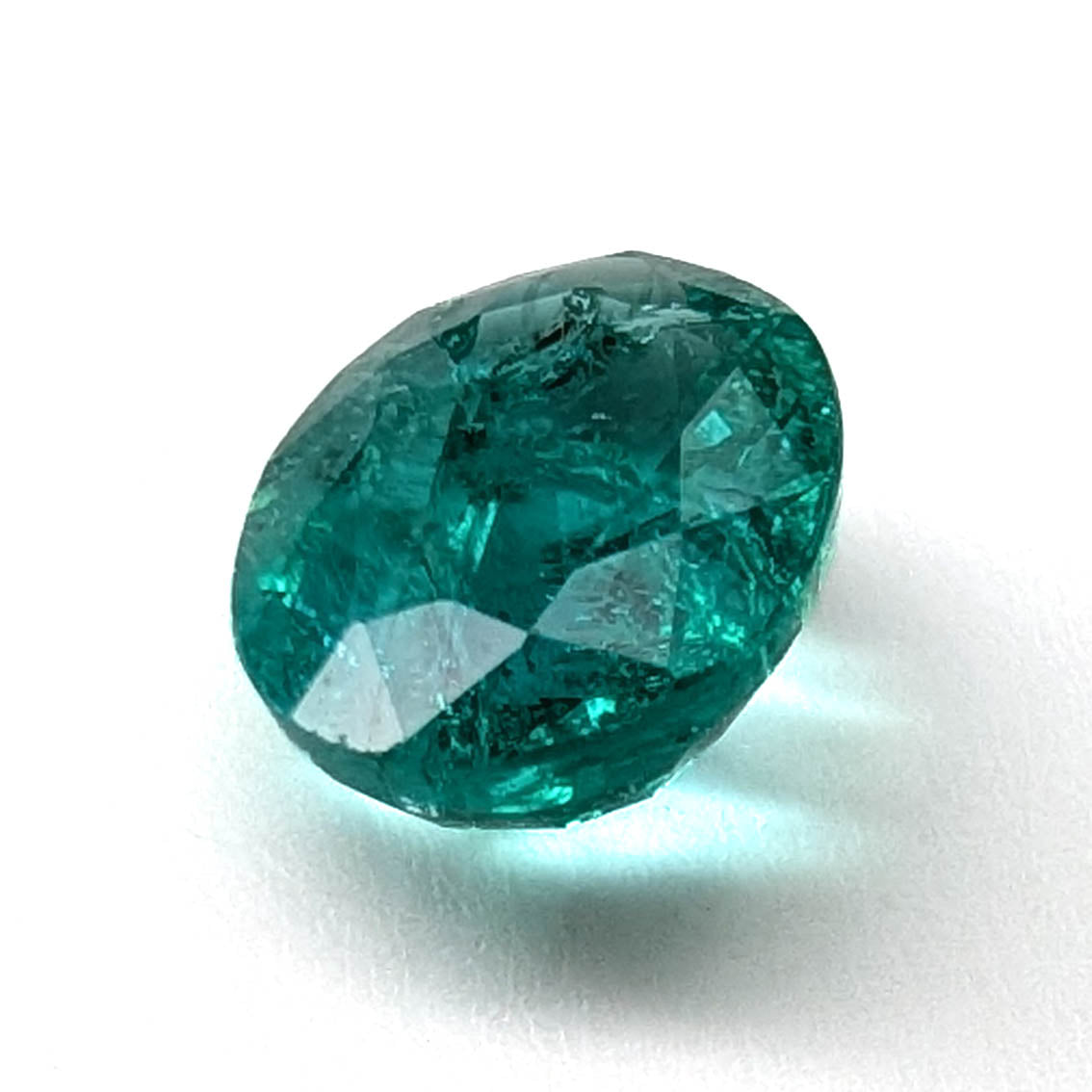 Emerald faceted oval gemstone, 1.90ct, angled view on a white background, view 6 of 13