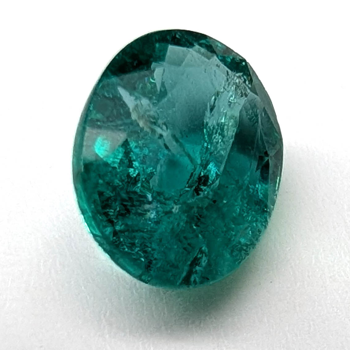 Emerald faceted oval gemstone, 1.90ct, close view of the face on a white background, view 8 of 13