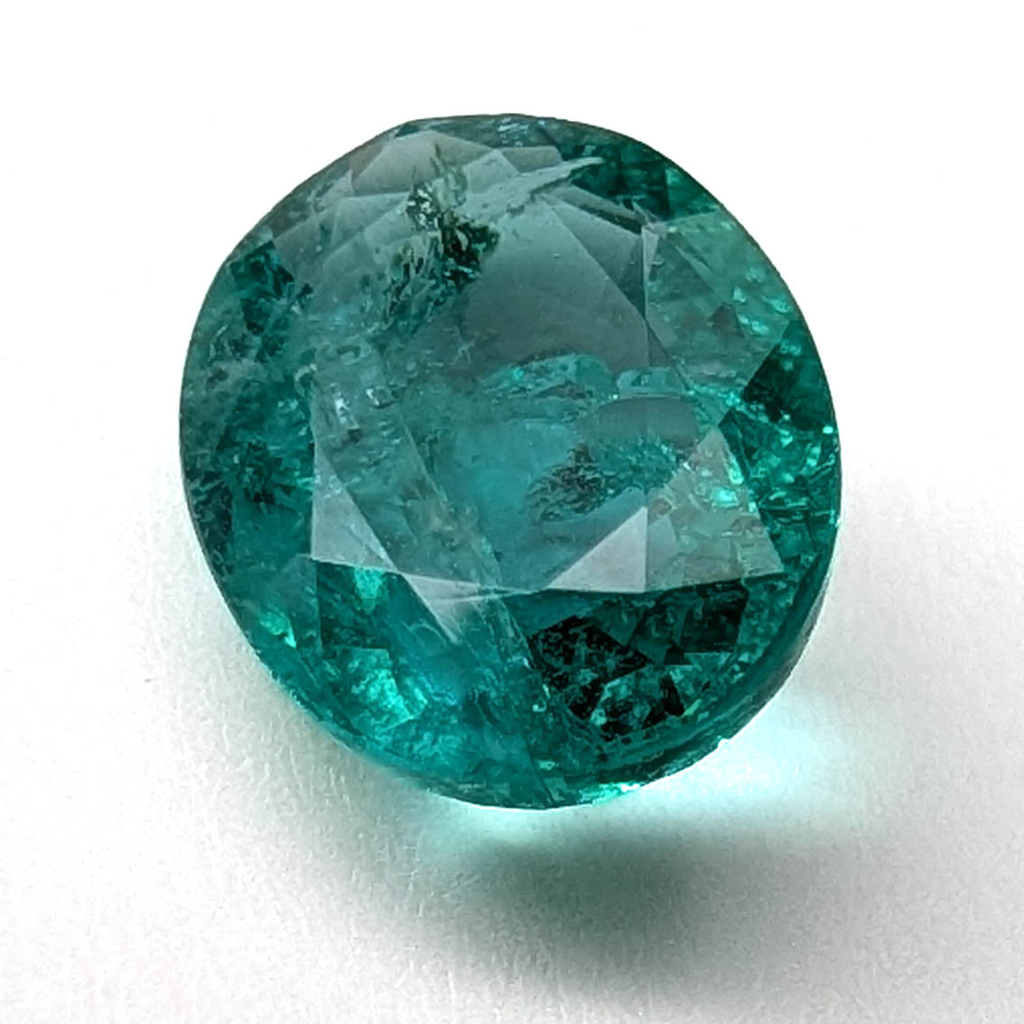 Emerald faceted oval gemstone, 1.90ct, close view of the face on a white background, view 10 of 13