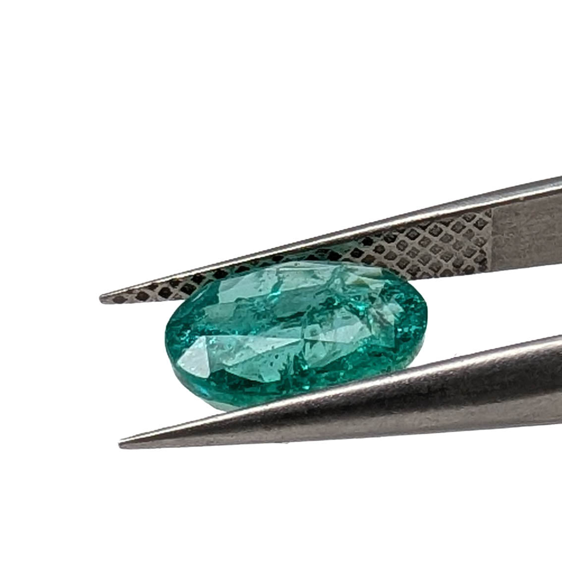 Emerald faceted oval gemstone, 1.90ct, held in tweezers, low side view, view 12 of 13