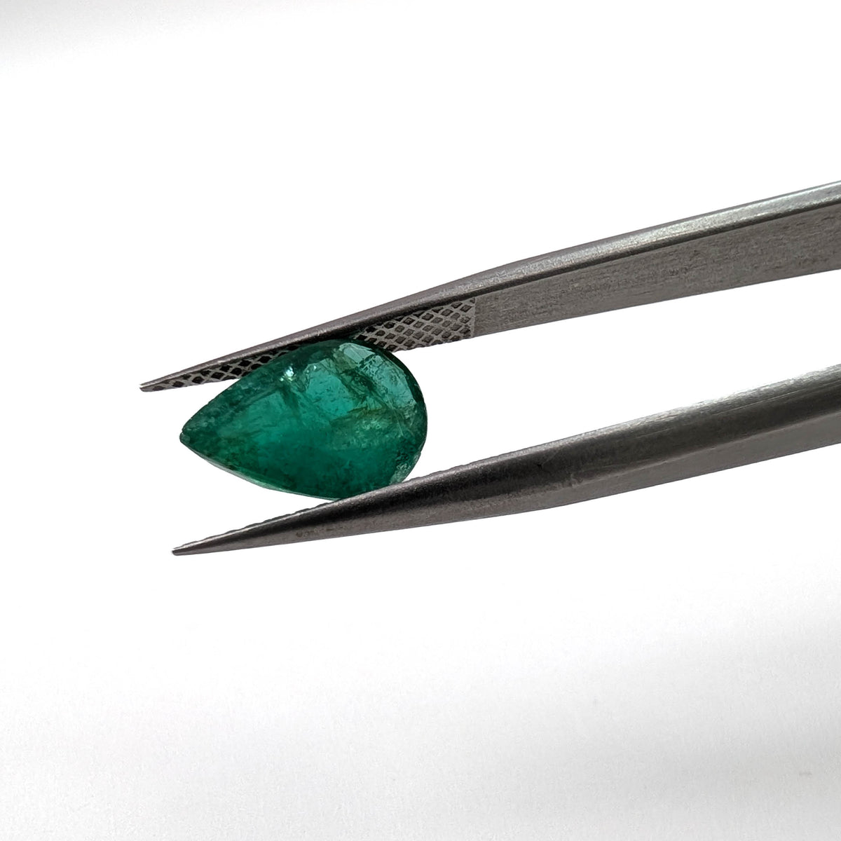 Emerald faceted pear cut gemstone, 1.93ct, held in tweezers, view 2 of 11