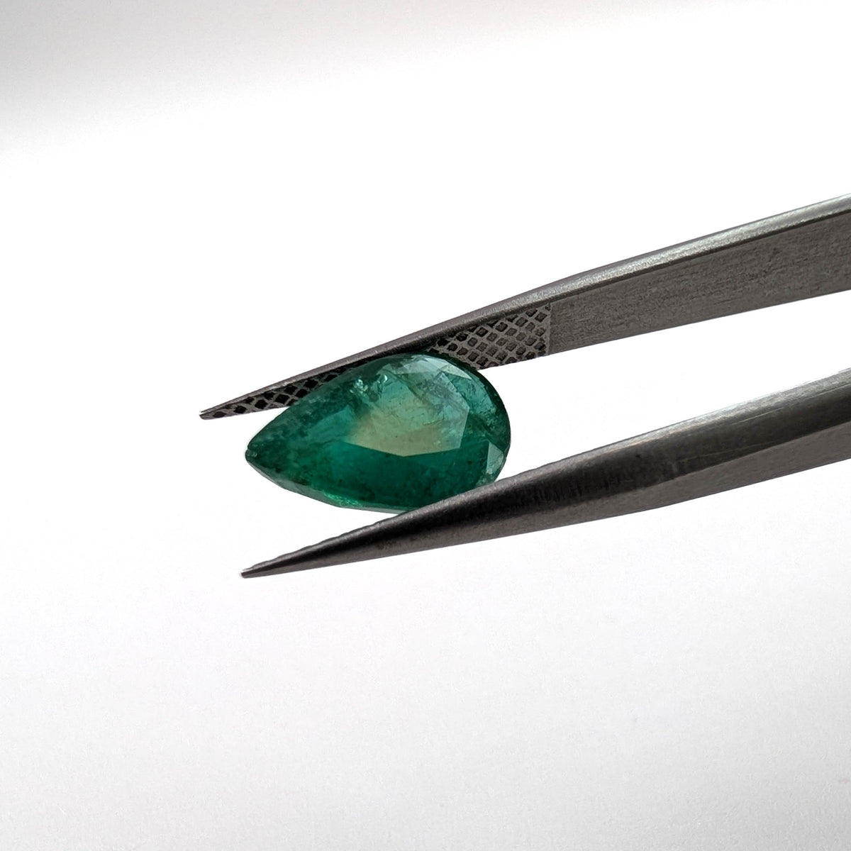 Emerald faceted pear cut gemstone, 1.93ct, held in tweezers, view 11 of 11