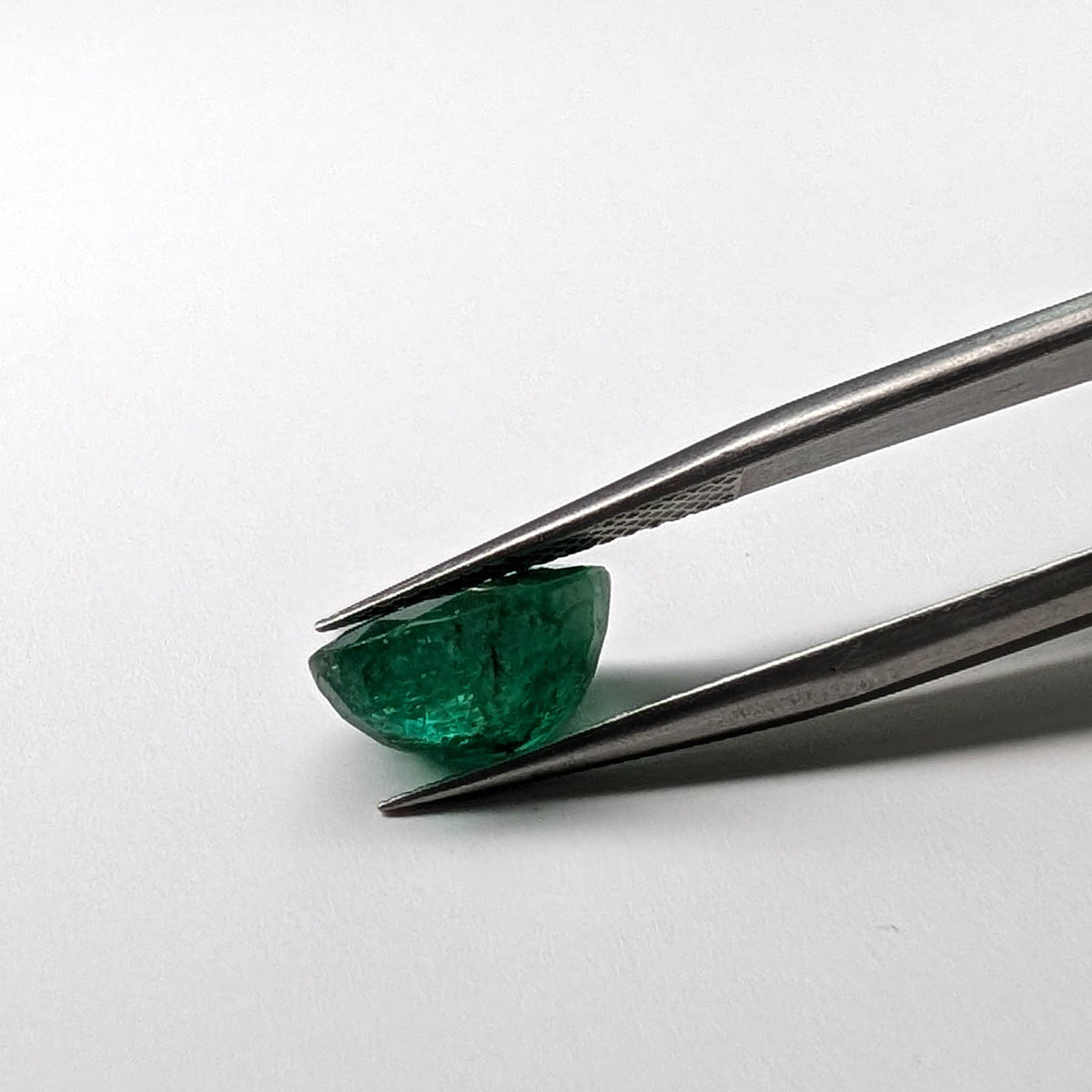 Emerald faceted pear cut gemstone, 3.60ct, held in tweezers, view 8 of 8