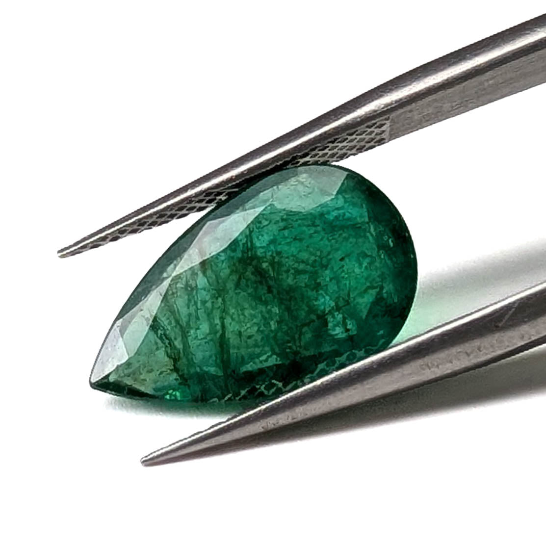 Emerald faceted pear cut gemstone, 3.95ct, held in tweezers, view 2 of 13