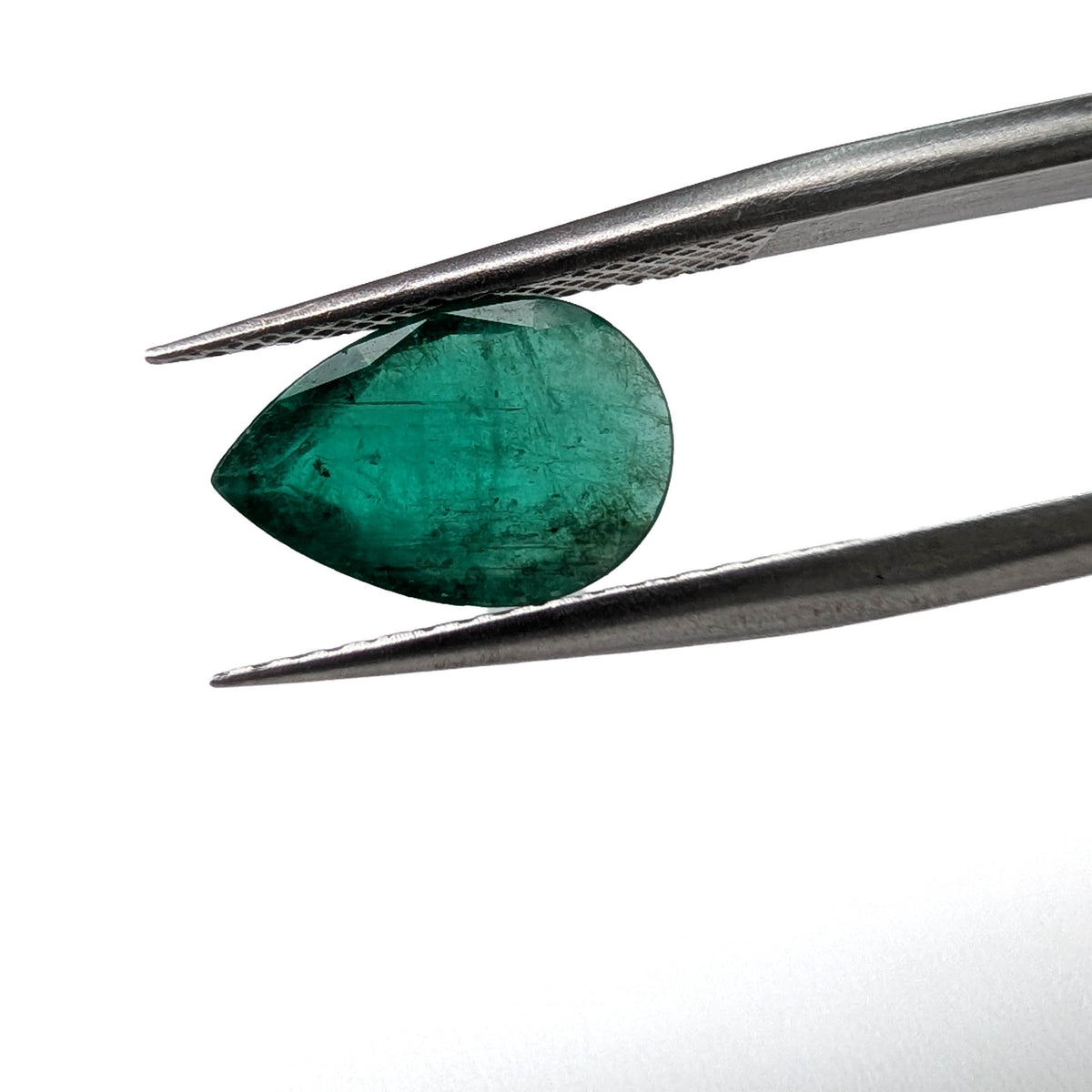 Emerald faceted pear gemstone, 1.60ct, held in tweezers, face-up, view 2 of 11