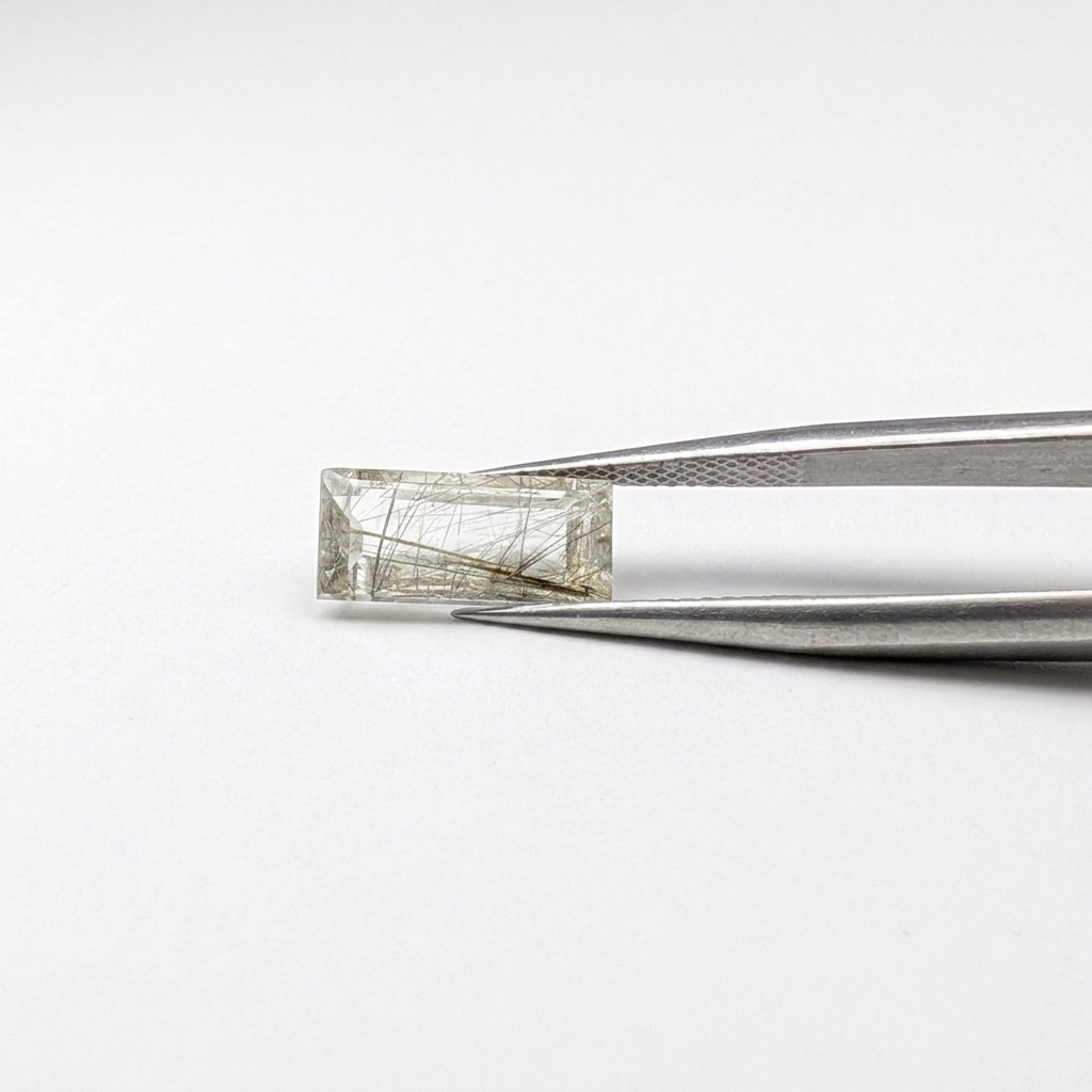 Actinolite quartz faceted baguette gemstone, 2.95ct, from Mount Breakenridge, Harrison Lake, BC, Canada, held in tweezers, view 2 of 10