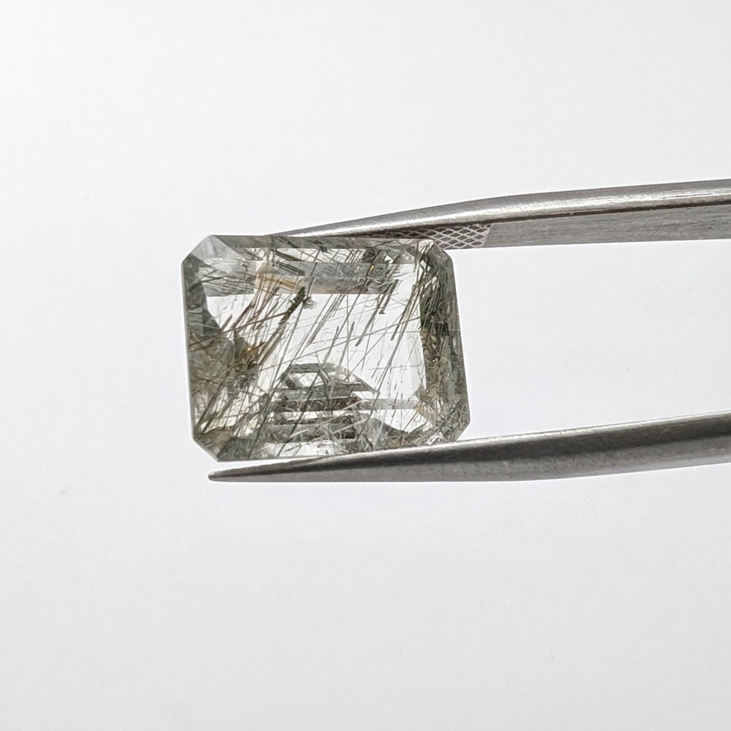 Actinolite quartz faceted emerald gemstone, 9.13ct, from Mount Breakenridge, Harrison Lake, BC, Canada, held in tweezers, view 2 of 11