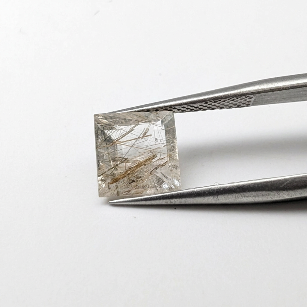 Actinolite quartz faceted square gemstone, 1.85ct, from Mount Breakenridge, Harrison Lake, BC, Canada, held in tweezers, view 2 of 10