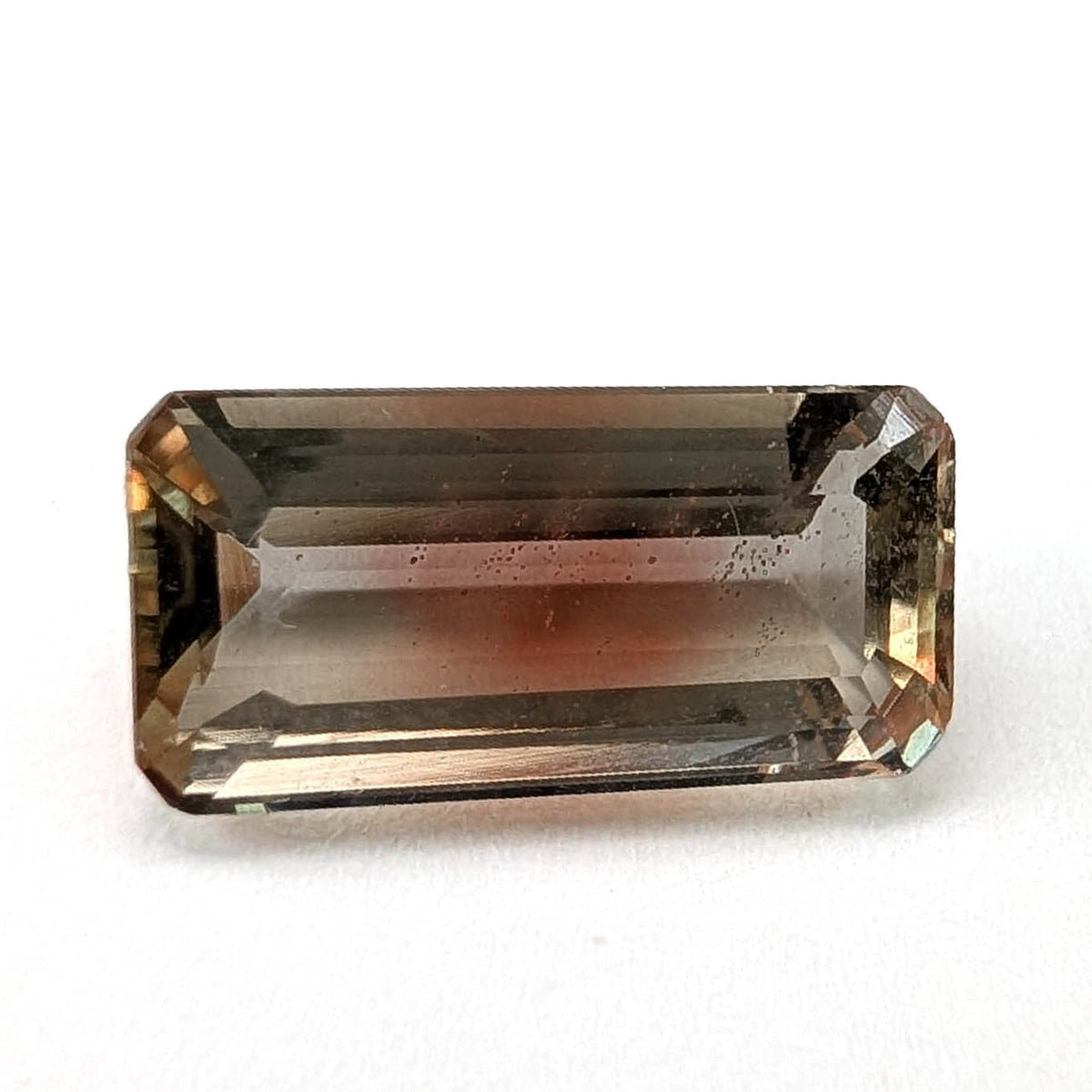 Oregon sunstone faceted emerald gemstone, 3.60ct, on a white background, view 1 of 7