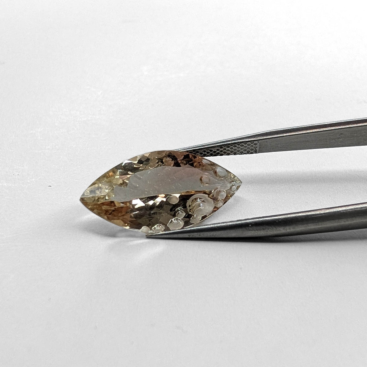 Oregon sunstone faceted marquise fantasy cut gemstone, 6.20ct, held in tweezers, view 2 of 8