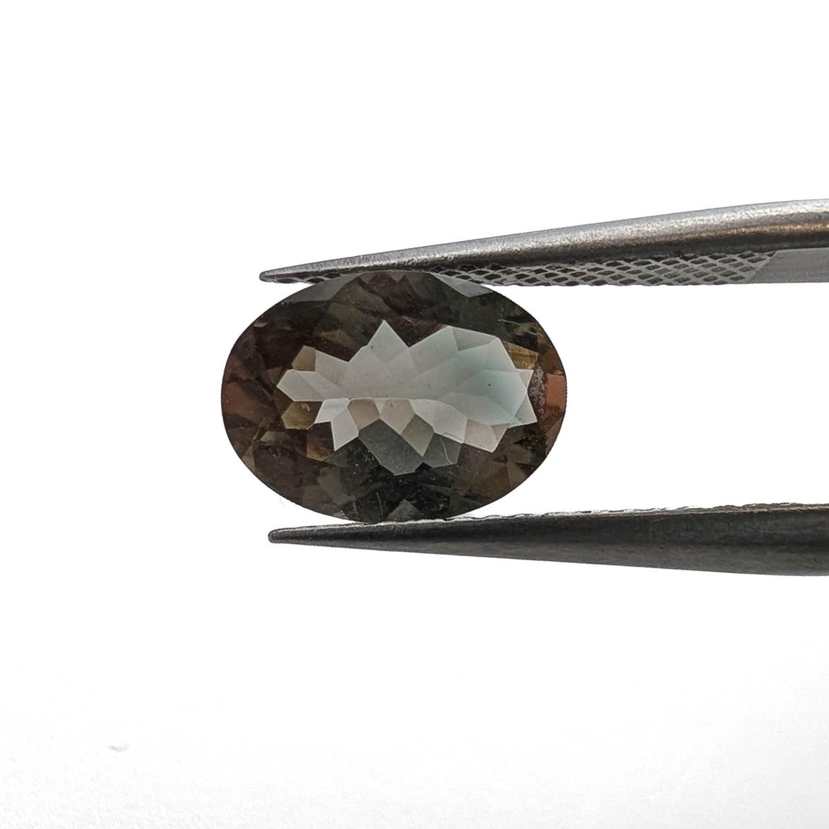 Oregon Sunstone faceted oval cut gemstone, 1.86ct, from Plush, Oregon, held in tweezers, view 2 of 10