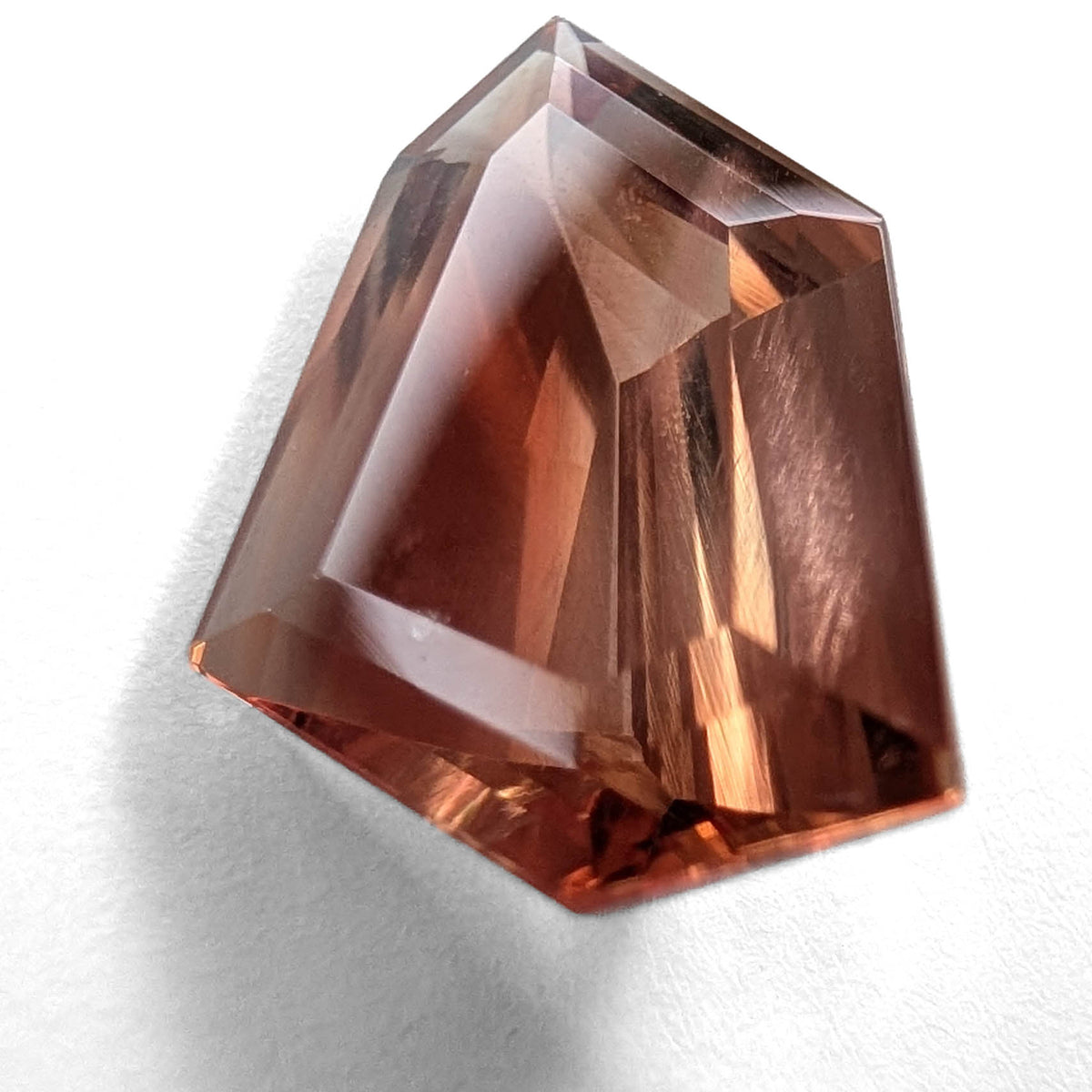 Oregon Sunstone faceted freeform step cut gemstone, 6.70ct, from Plush, Oregon, on a white background, view 1 of 10