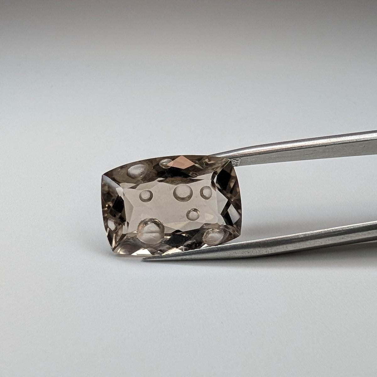 Smoky Quartz faceted cushion fantasy cut gemstone, 11.00ct, held in tweezers, view 2 of 12