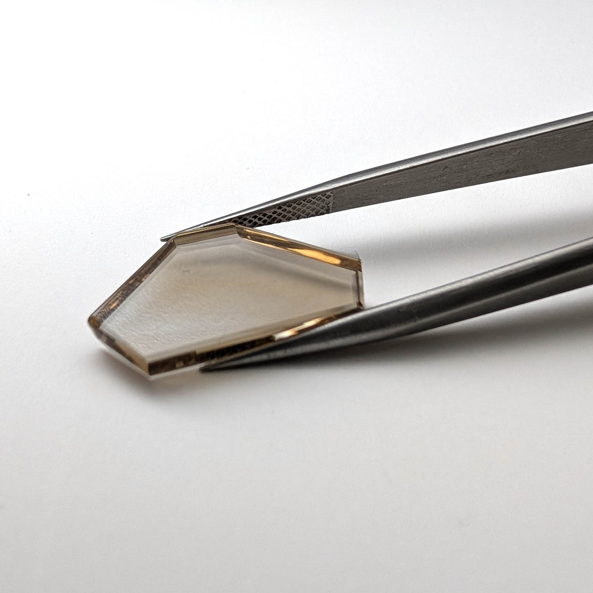 Smoky Quartz faceted freeform flatback step cut gemstone, 5.35ct, held in tweezers, view 2 of 8