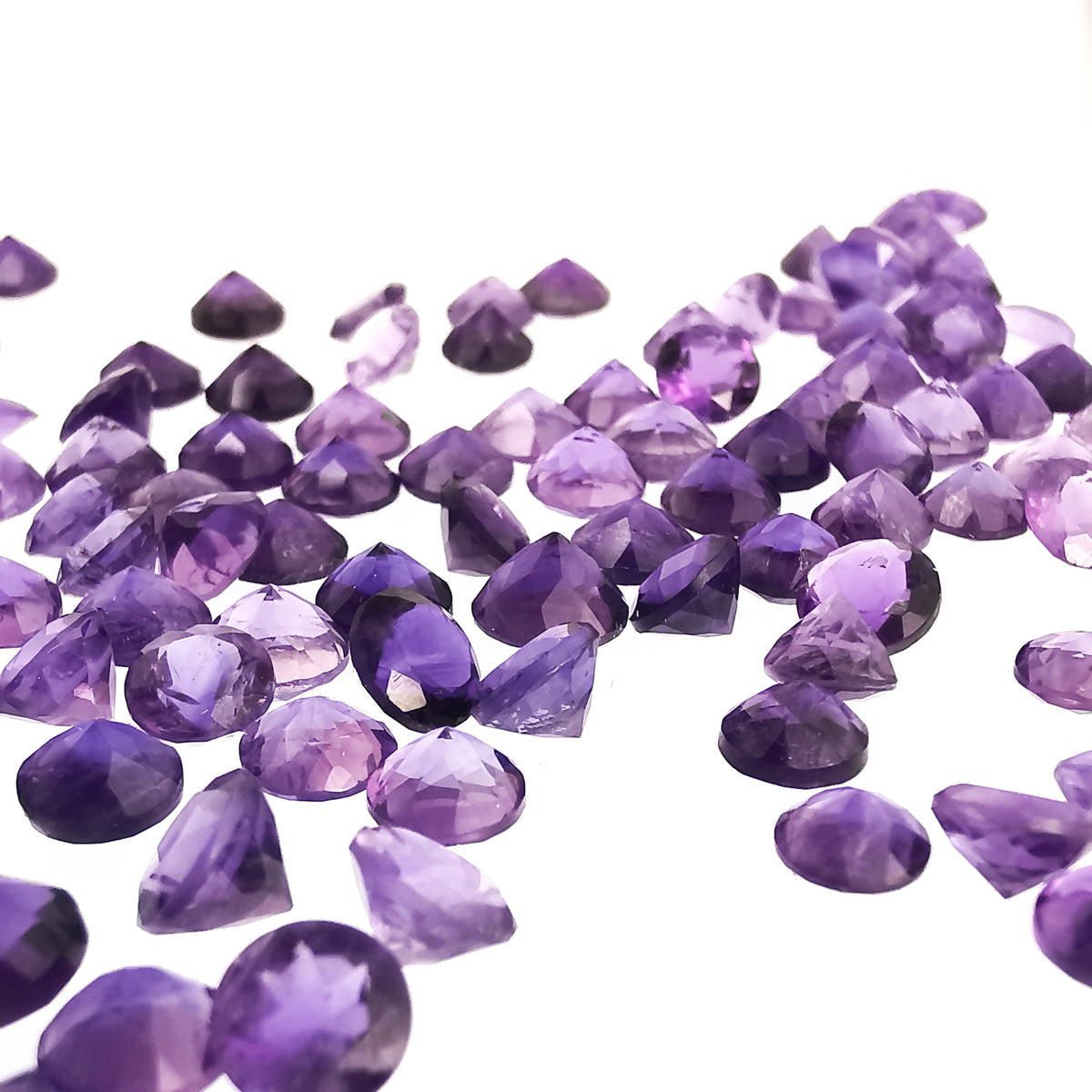Faceted amethyst rounds, Brazil: scatter of loose rounds