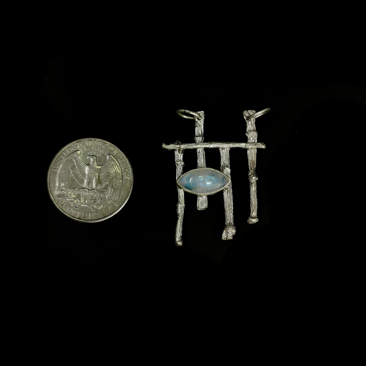 Twig and moonstone pendant: pendant beside a coin for scale
