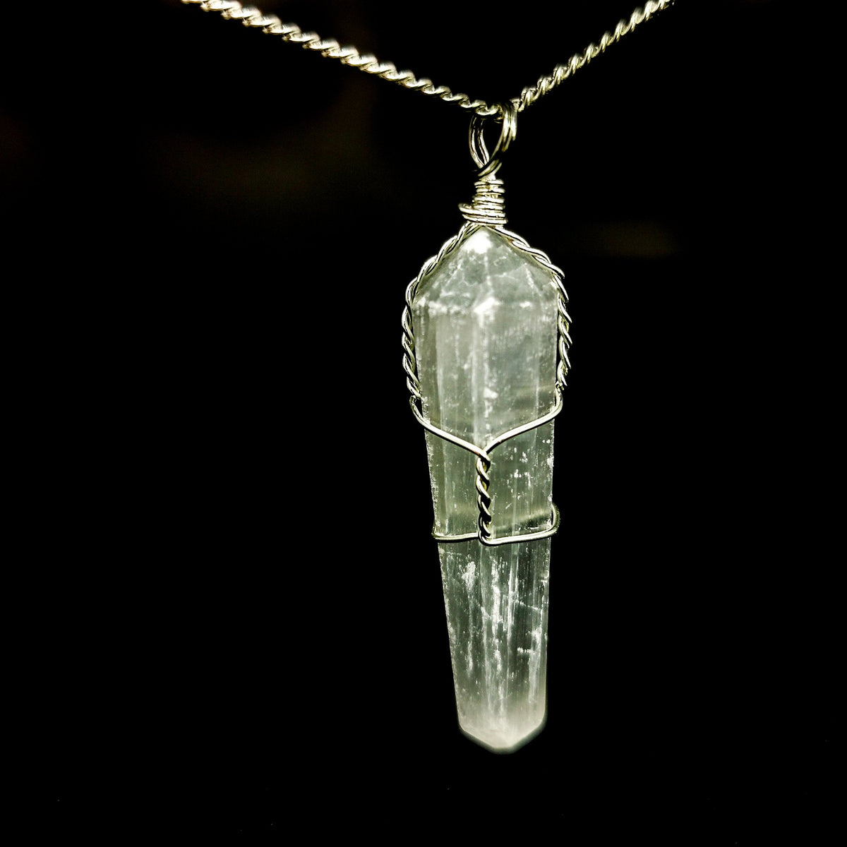 Wire wrap crystal pendant – quartz on chain, dark background