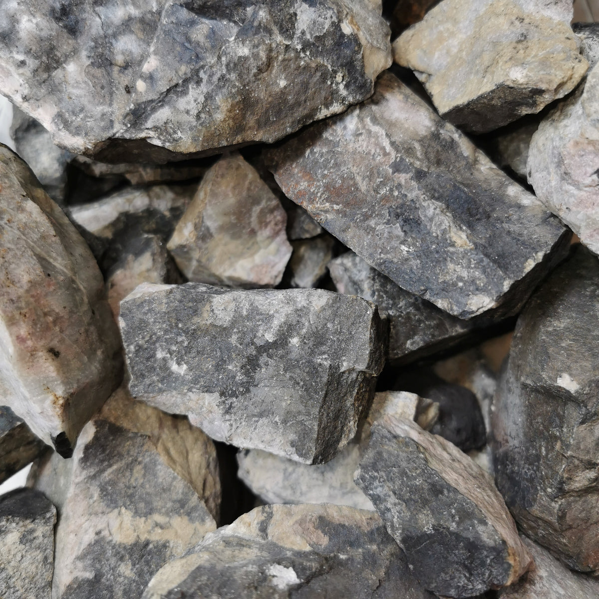 Rhodonite yellow rough from Cowichan Lake, BC – close-up of a bulk bin of rough
