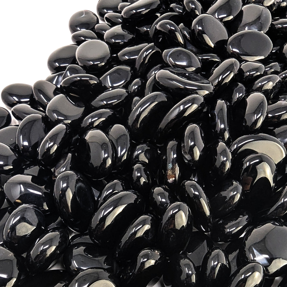 Black onyx oval tumble from Brazil – close-up of a pile