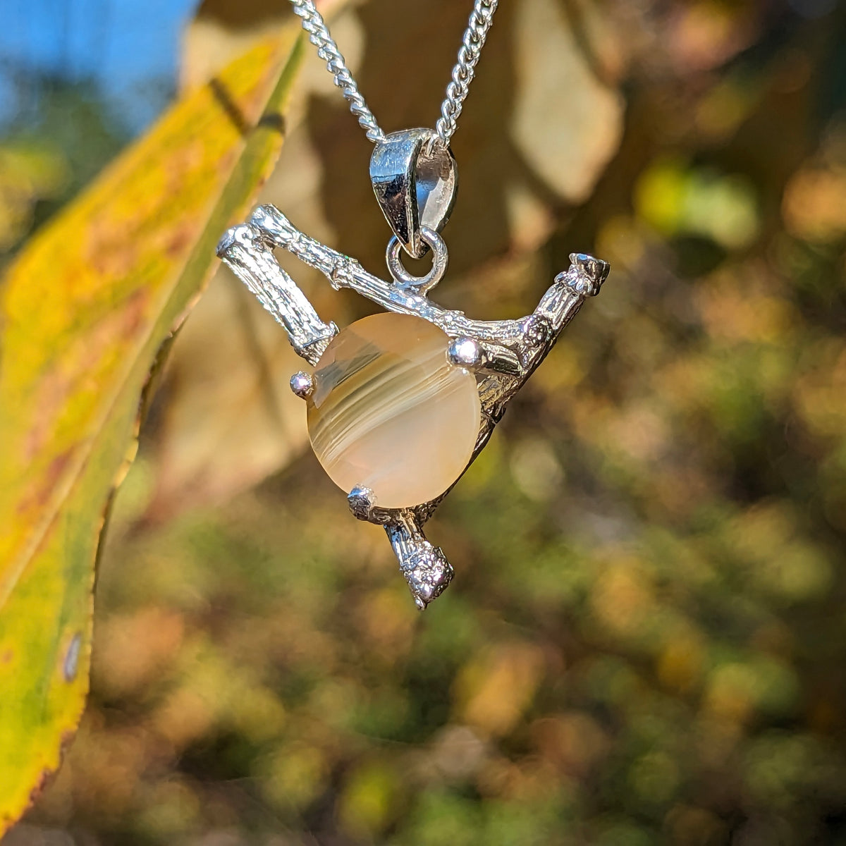 Twig and BC agate pendant in sterling silver – pendant on a leaf