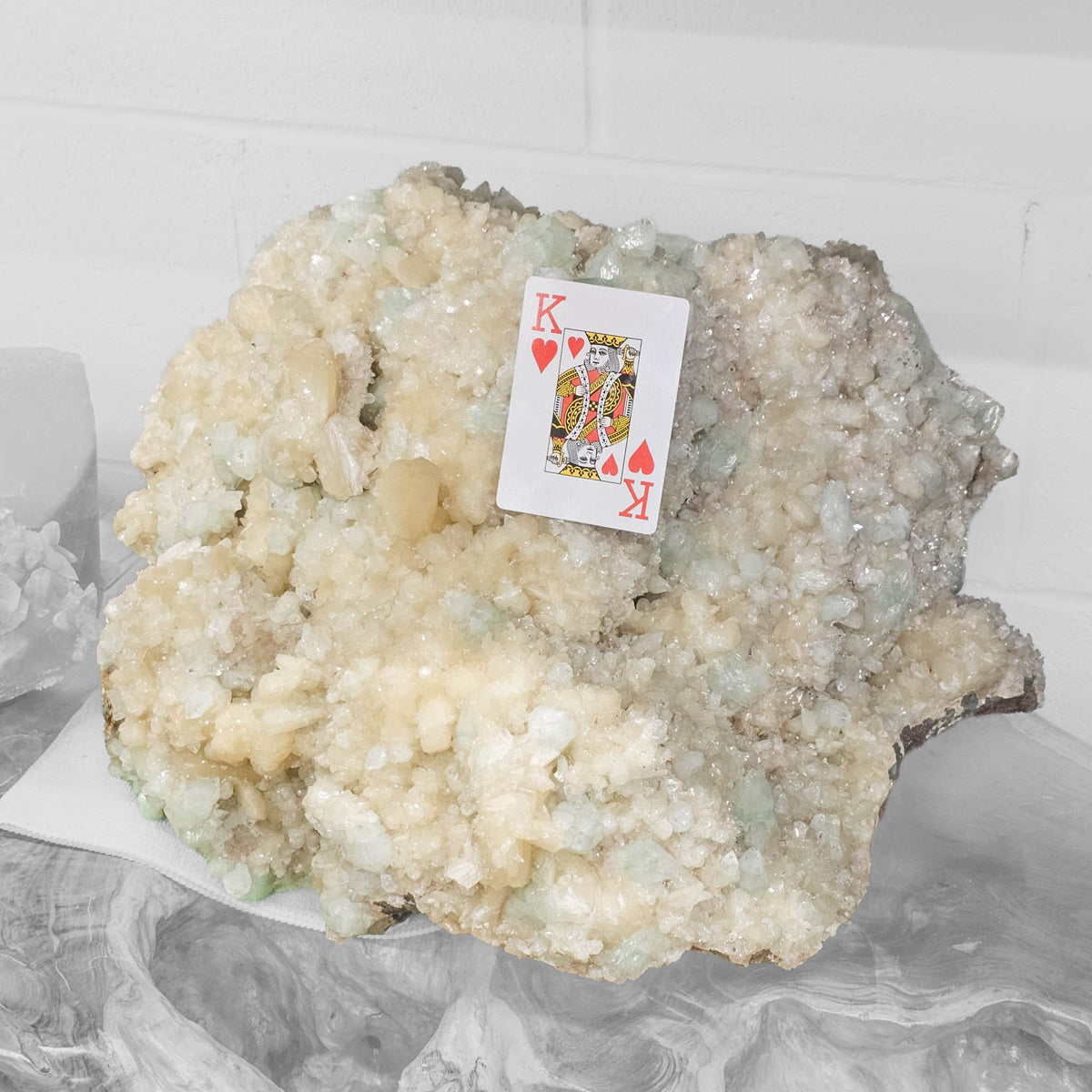 Stilbite with green apophyllite crystal cluster from Pune, India – with a playing card for scale on display