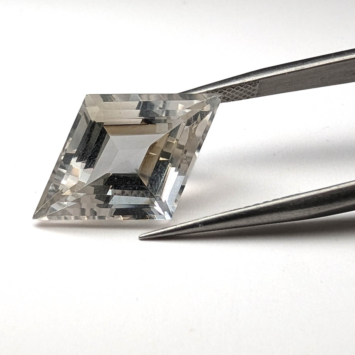 Clear quartz faceted lozenge gemstone, 9.36ct, from the King Citrine Mine, Mount Breakenridge, Harrison Lake, BC, Canada, held in tweezers, view 2 of 13