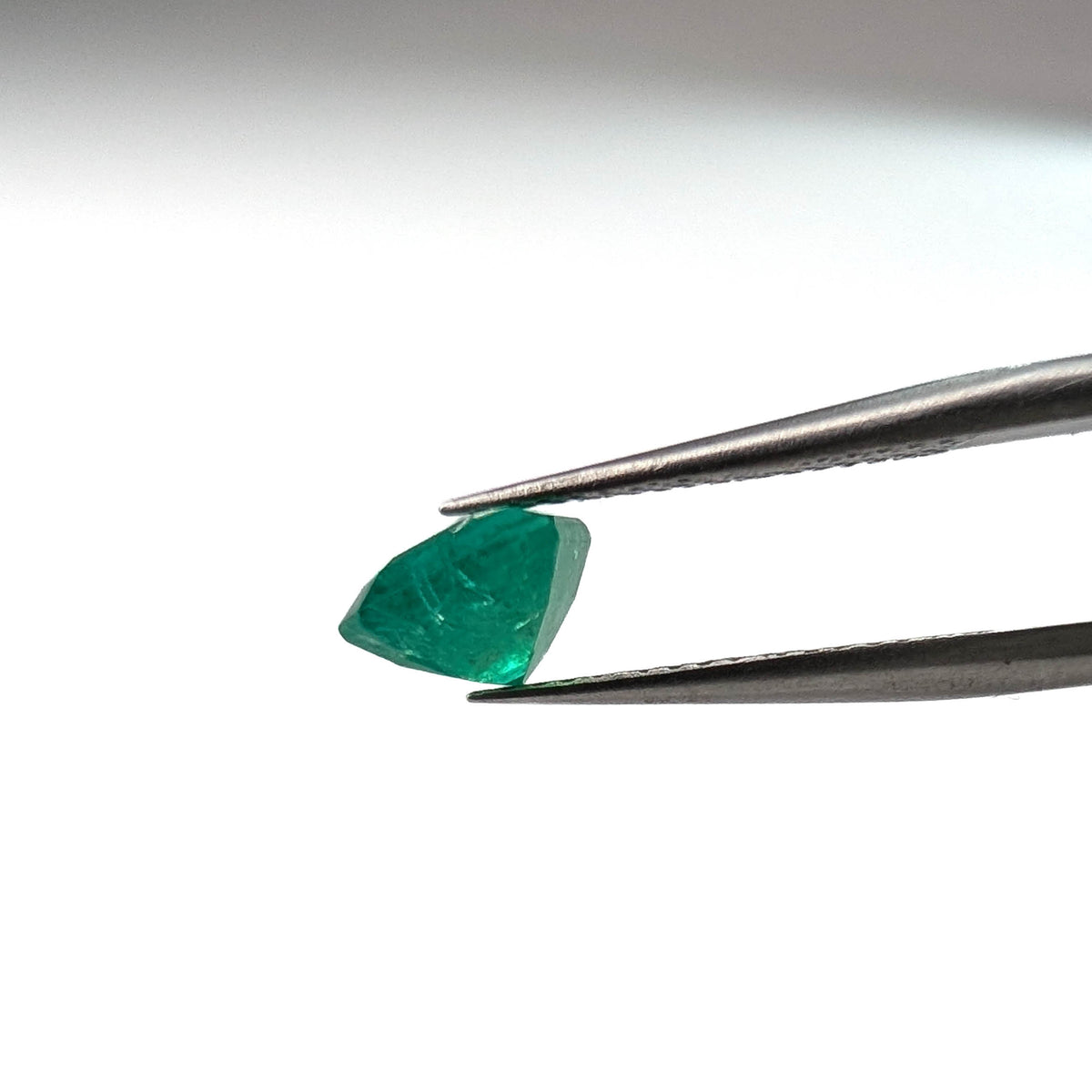 Emerald faceted emerald cut gemstone, 1.53ct, held in tweezers, view 12 of 12