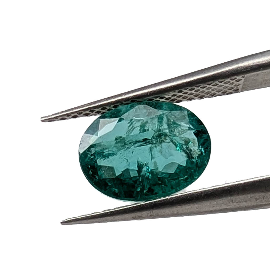 Emerald faceted oval gemstone, 1.90ct, held in tweezers, side view, view 2 of 13