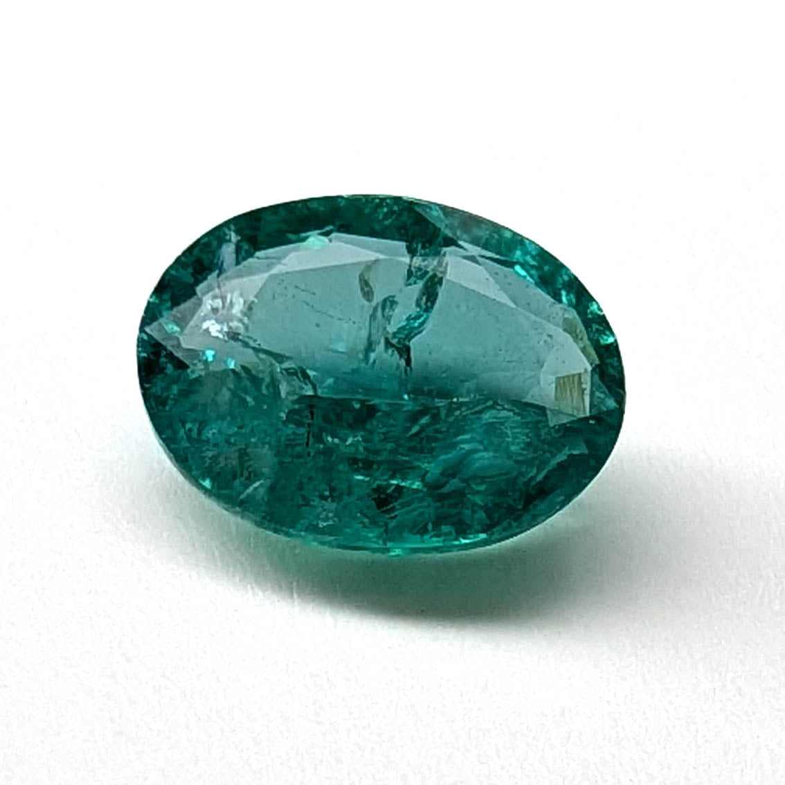 Emerald faceted oval gemstone, 1.90ct, angled view on a white background, view 3 of 13