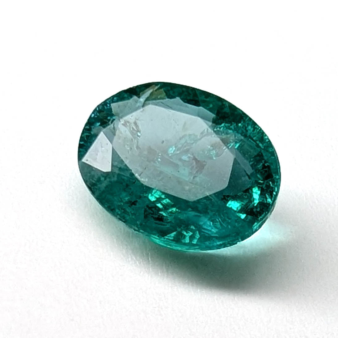 Emerald faceted oval gemstone, 1.90ct, angled view on a white background, view 4 of 13