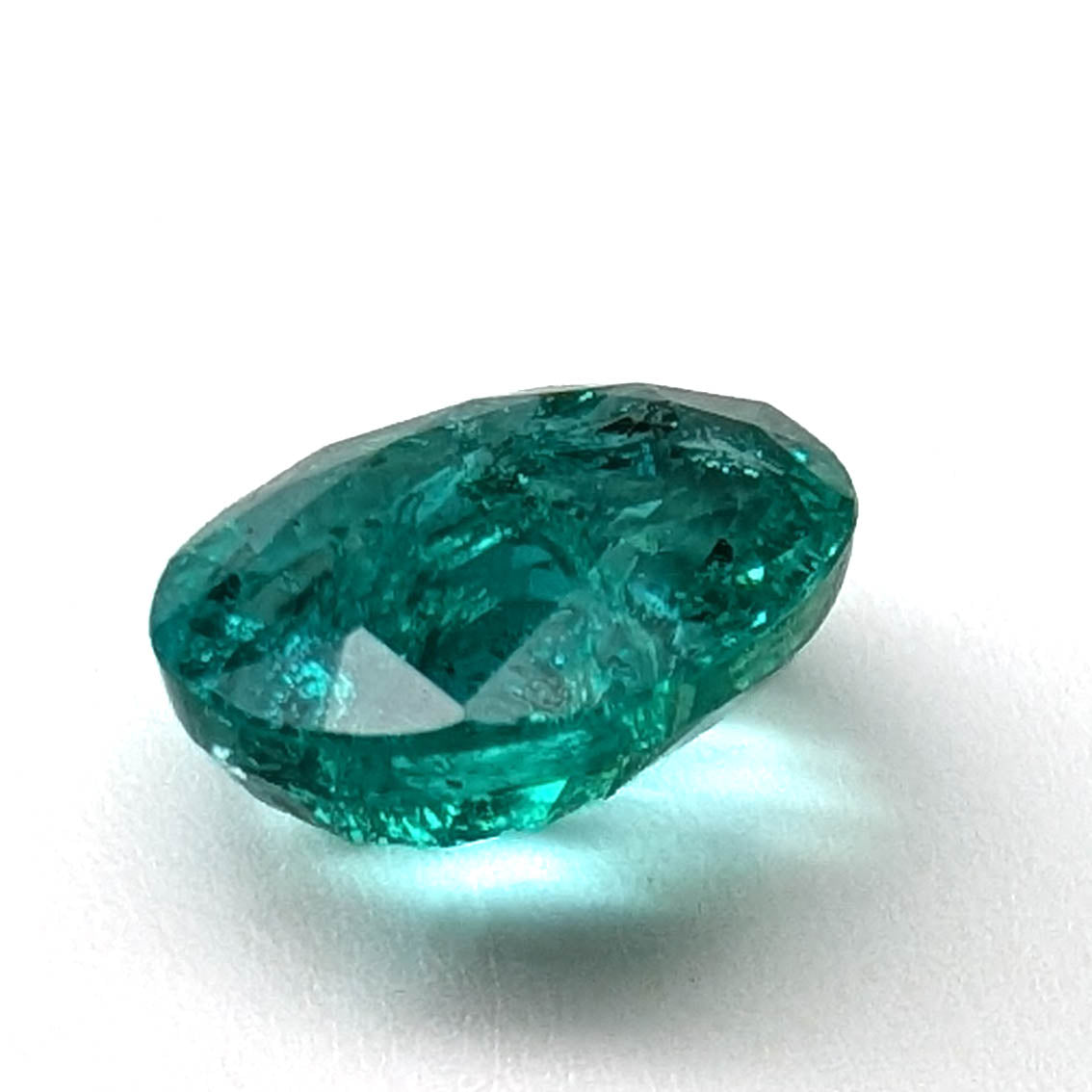 Emerald faceted oval gemstone, 1.90ct, low side view showing the profile on a white background, view 7 of 13