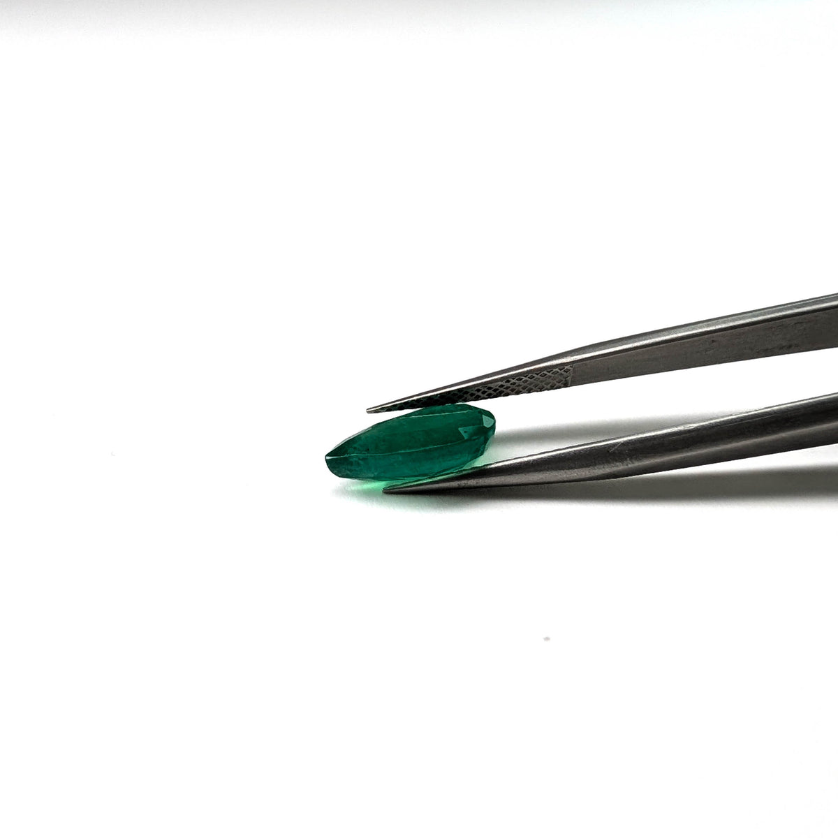 Emerald faceted pear cut gemstone, 2.57ct, held in tweezers, view 15 of 15