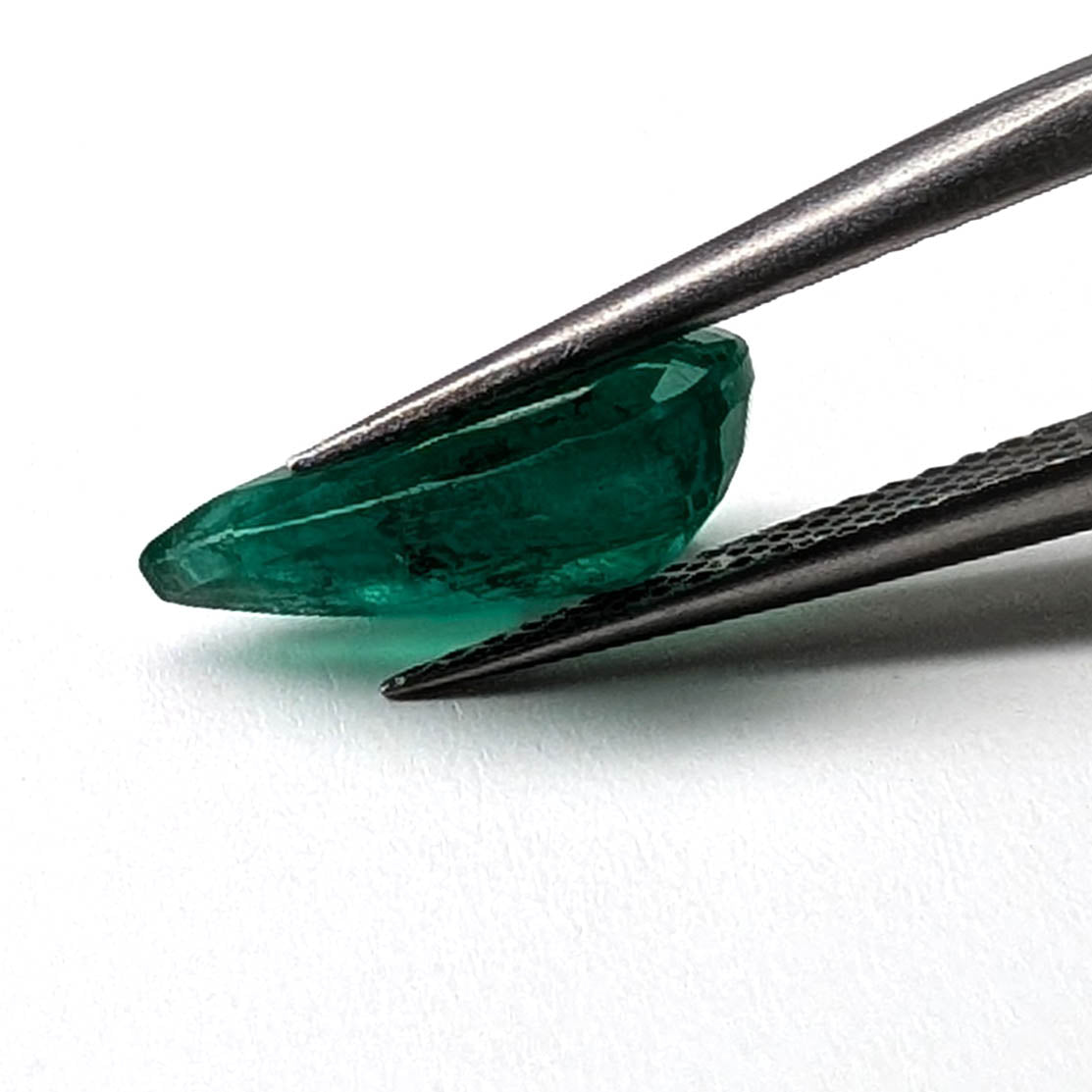Emerald faceted pear cut gemstone, 2.62ct, held in tweezers, view 9 of 9