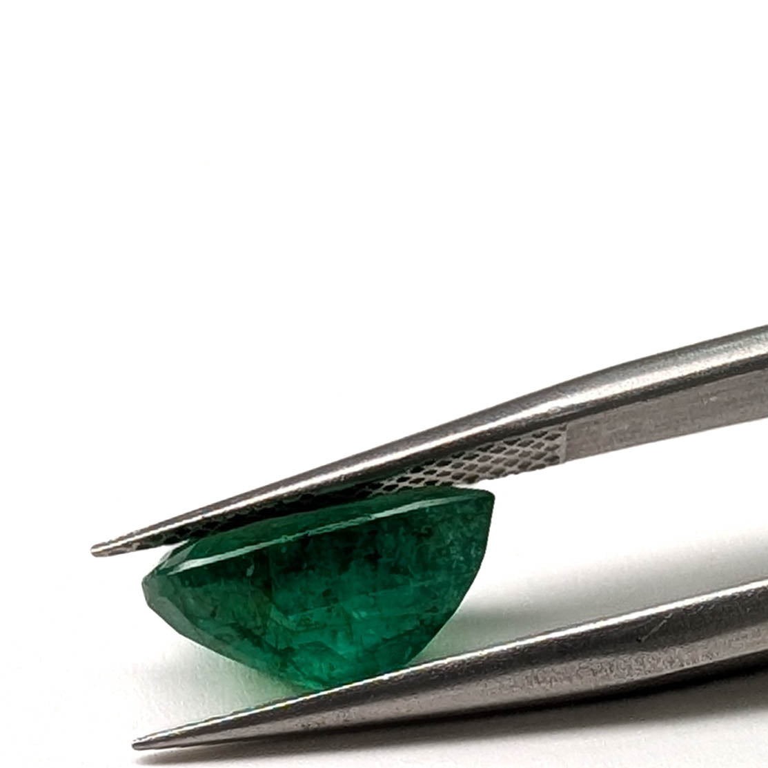 Emerald faceted pear cut gemstone, 2.82ct, held in tweezers, view 12 of 12