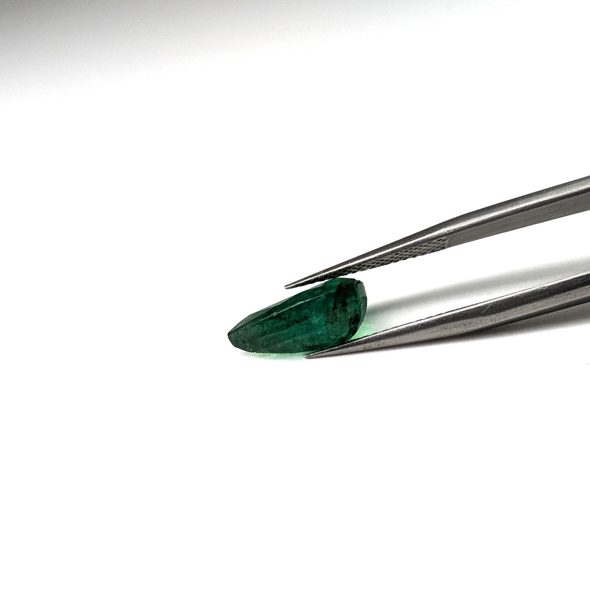Emerald faceted pear cut gemstone, 3.50ct, held in tweezers, view 11 of 11