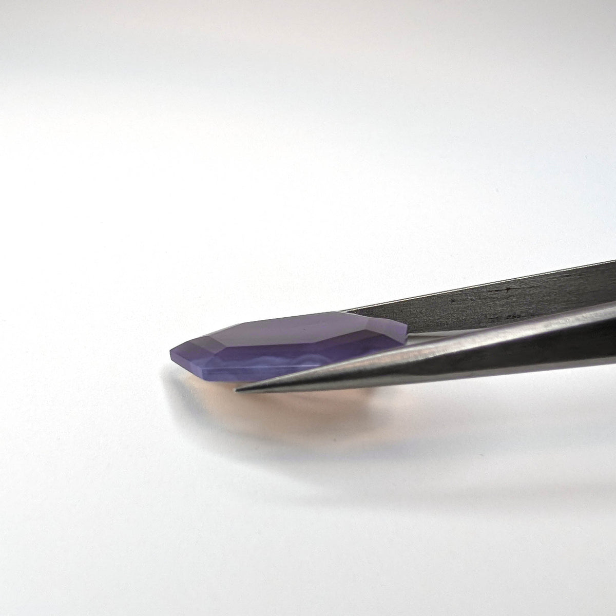 Holly Blue agate faceted freeform step tablet cut gemstone, 12.43ct, from Holley, Oregon, held in tweezers, view 9 of 13