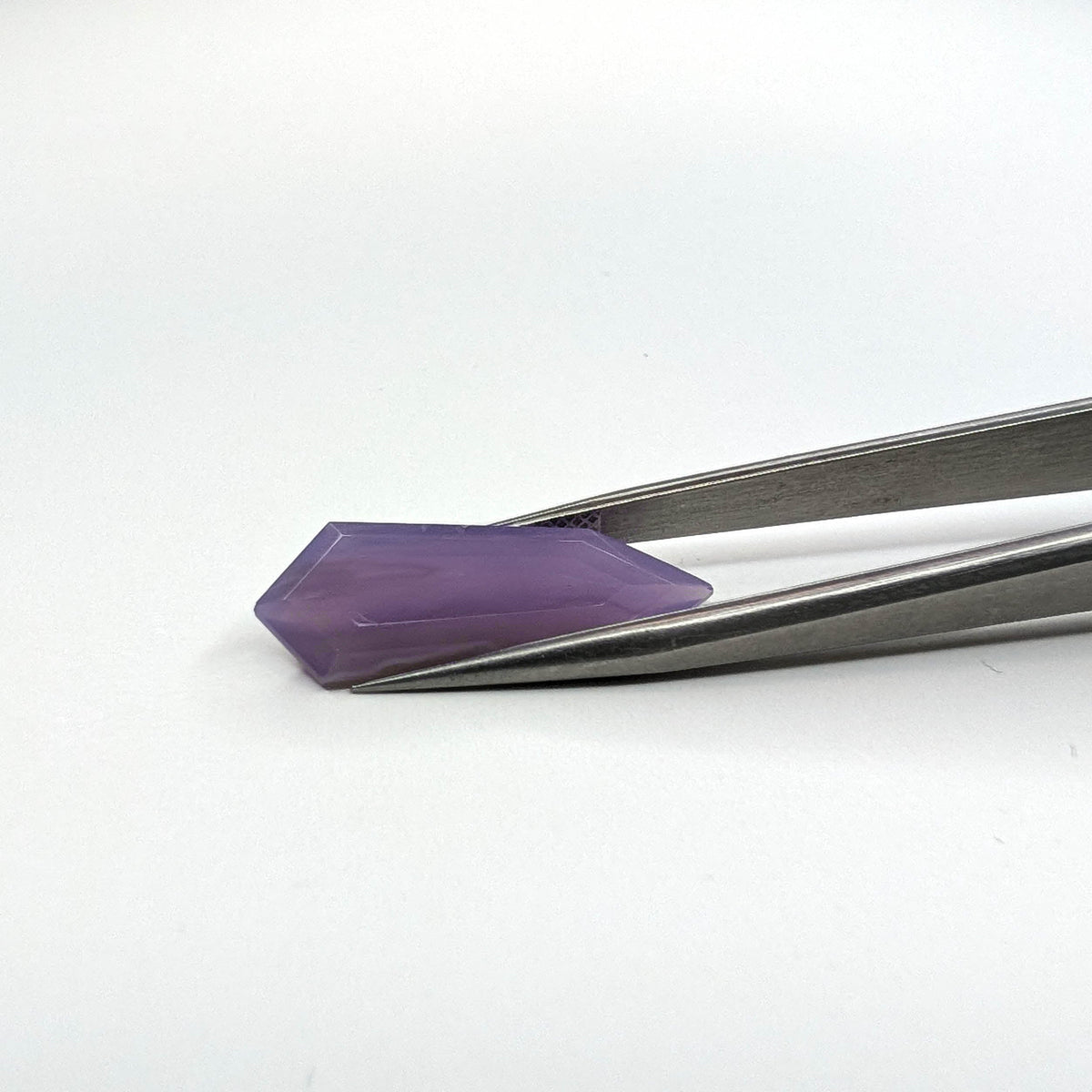 Holly Blue agate faceted freeform step tablet cut gemstone, 6.18ct, from Holley, Oregon, held in tweezers, view 2 of 8