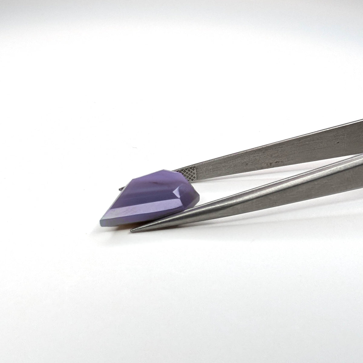 Holly Blue agate faceted freeform step tablet cut gemstone, 8.22ct, from Holley, Oregon, held in tweezers, view 9 of 9