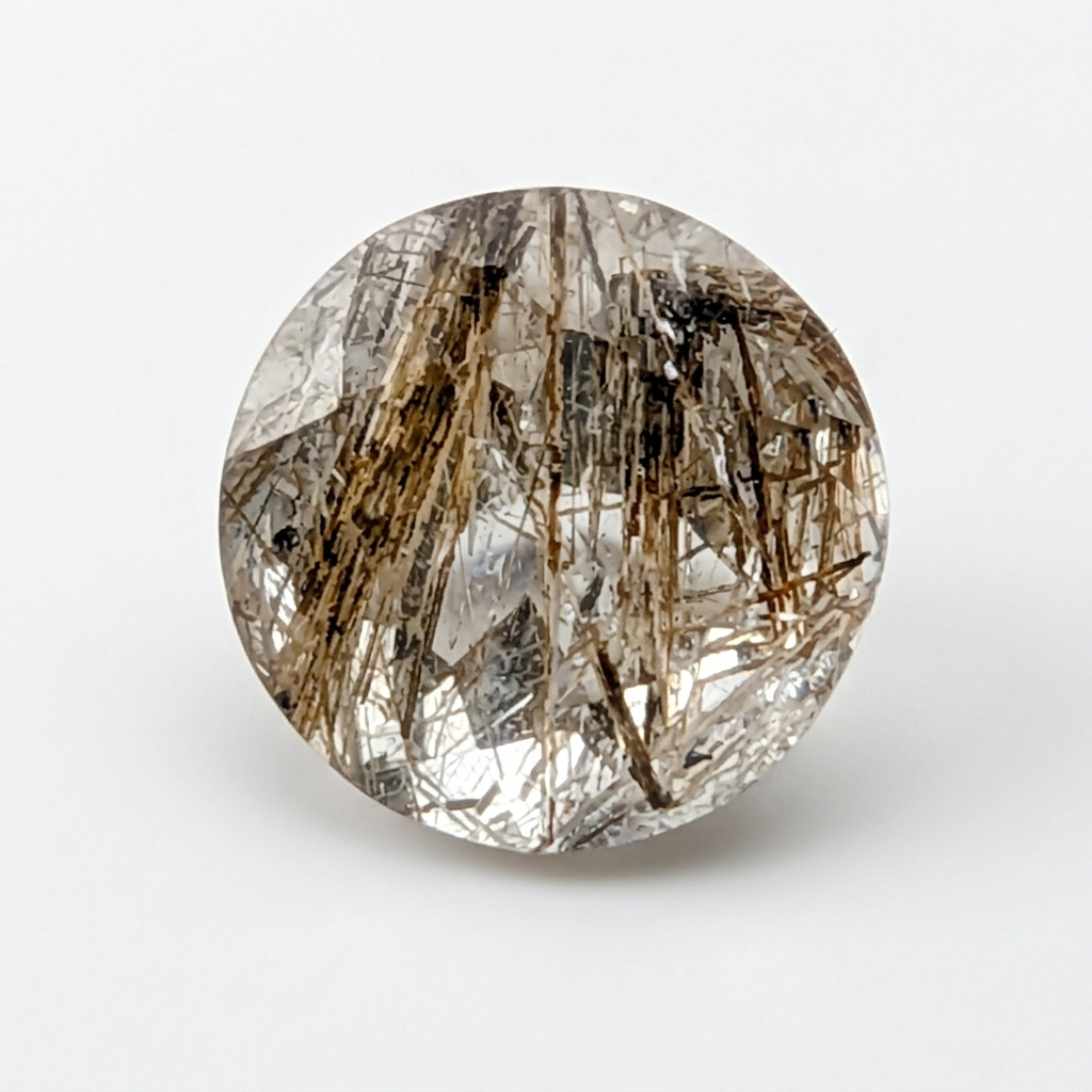 Actinolite quartz faceted round gemstone, 1.18ct, from Mount Breakenridge, Harrison Lake, BC, Canada, on a white background, view 1 of 10