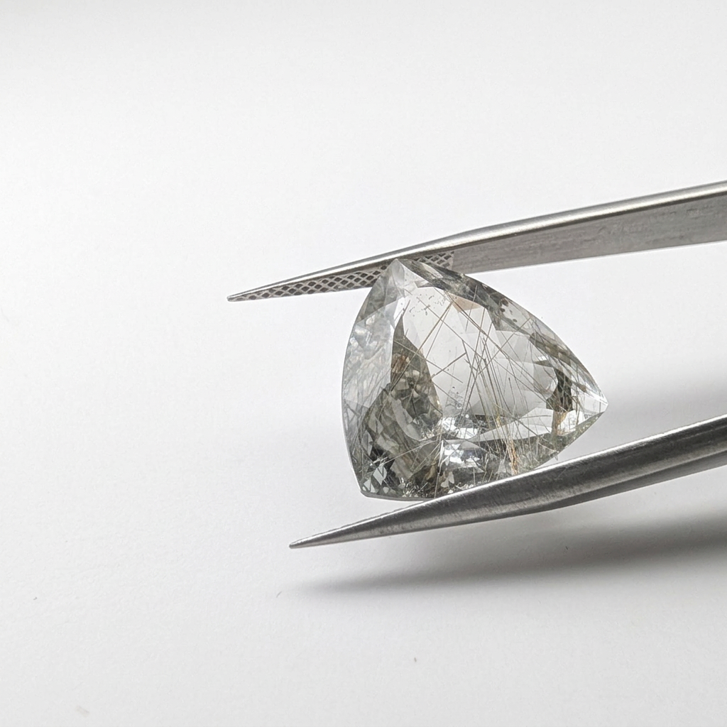 Actinolite quartz faceted trillion gemstone, 13.20ct, from Mount Breakenridge, Harrison Lake, BC, Canada, held in tweezers, view 2 of 17