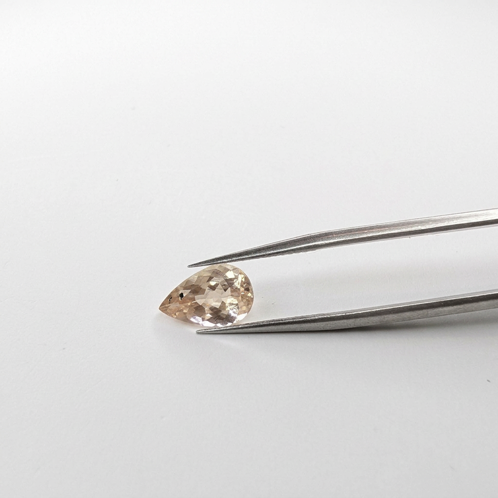 Oregon sunstone faceted pear gemstone, 2.21ct, held in tweezers, view 3 of 7