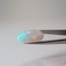 Ethiopian solid opal cabochon oval gemstone, 10.07ct, held in tweezers, view 8 of 8