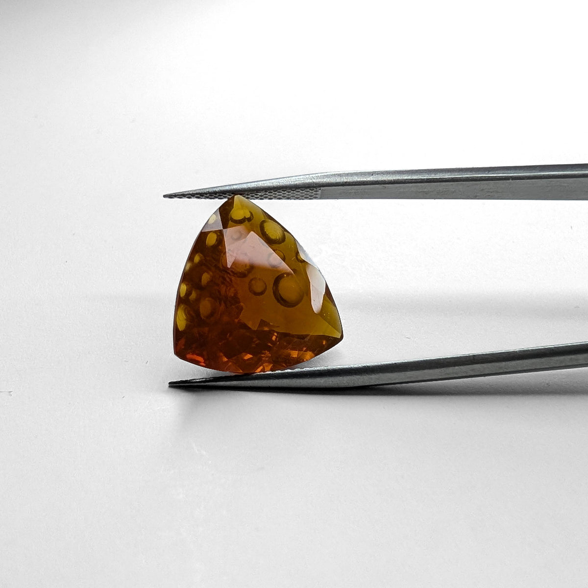 Oregon fire opal faceted trillion fantasy cut gemstone, 8.88ct, held in tweezers, view 2 of 10