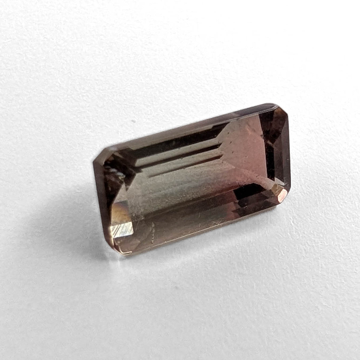 Oregon Sunstone faceted emerald cut gemstone, 2.39ct, from Plush, Oregon, on a white background, view 1 of 11